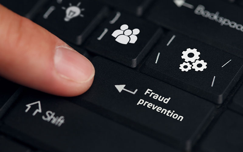 Finger pointing at a keyboard button that says Fraud Prevention